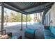 Covered patio with seating area overlooking the backyard pool and lush landscaping at 4509 Paseo Del Ray Dr, Las Vegas, NV 89121