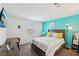 Bedroom featuring a TV, desk and aqua accent wall at 4612 Townwall St, Las Vegas, NV 89115