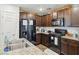 Modern kitchen with stainless steel appliances, granite countertops, and dark wood cabinetry at 4612 Townwall St, Las Vegas, NV 89115