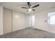 Spacious bedroom featuring neutral carpeting, a ceiling fan, and closet storage, with a door leading to the bathroom at 5101 Village Dr, Las Vegas, NV 89142