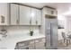 Bright kitchen featuring stainless steel refrigerator, white cabinets, quartz countertops, with adjacent dining area at 5101 Village Dr, Las Vegas, NV 89142