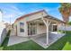 Beautiful backyard with covered patio, mature palm tree, and lush artificial grass at 5762 Yerington Ave, Las Vegas, NV 89110