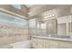 Bathroom featuring dual vanities, shower over tub, and large mirror with great lighting at 5762 Yerington Ave, Las Vegas, NV 89110