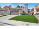 Inviting home featuring a 2-car garage, red tile roof, chimney, and lush artificial lawn at 5762 Yerington Ave, Las Vegas, NV 89110