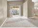 Open living space with neutral carpet, sliding glass doors to the backyard, and adjacent bathroom view at 5762 Yerington Ave, Las Vegas, NV 89110