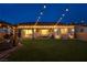 Well-manicured backyard featuring a covered patio, lush lawn, string lights, and cozy seating areas perfect for relaxing at 6325 Gambetta St, Las Vegas, NV 89115