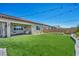 Wide view of the backyard with green turf, hardscape border, and patio seating at 6325 Gambetta St, Las Vegas, NV 89115