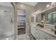 Well-lit bathroom with double sinks, glass shower, and view to bedroom at 6325 Gambetta St, Las Vegas, NV 89115