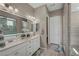 Bright bathroom showcasing double sinks with decorative mirrors and a glass-enclosed shower at 6325 Gambetta St, Las Vegas, NV 89115