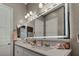 Elegant bathroom featuring a double sink vanity with a large illuminated mirror and modern fixtures at 6325 Gambetta St, Las Vegas, NV 89115