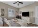 Cozy bedroom featuring a ceiling fan, plush bedding, and a stylish dresser with a large television at 6325 Gambetta St, Las Vegas, NV 89115