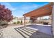 Well-maintained backyard with a covered patio, decorative retaining wall, and tidy gravel landscaping at 656 Thornewood Pl, Las Vegas, NV 89123