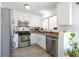 Modern kitchen with stainless steel appliances, granite countertops, and wood-look flooring at 656 Thornewood Pl, Las Vegas, NV 89123