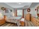 Bright bedroom with a floral quilt, light wood floors, window, and bench at the foot of the bed at 6868 Sky Pointe Dr # 1089, Las Vegas, NV 89131