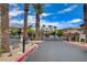 Gated entry to a residential community with desert landscaping and mature palm trees at 6868 Sky Pointe Dr # 1089, Las Vegas, NV 89131