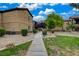 Condominium complex featuring sidewalks, grass, gravel landscaping, and desert flora at 6868 Sky Pointe Dr # 1089, Las Vegas, NV 89131