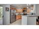 Updated kitchen features light wood cabinets, stainless appliances, breakfast bar, and tile floors at 6868 Sky Pointe Dr # 1089, Las Vegas, NV 89131