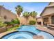 Backyard features a gorgeous pool and spa surrounded by lush greenery and a rock waterfall feature under a bright blue sky at 7013 Bisoni St, Las Vegas, NV 89149