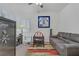 Cozy bedroom featuring a gray sofa, desk, playpen and striped rug for a comfortable and inviting space at 7013 Bisoni St, Las Vegas, NV 89149