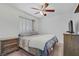 Comfortable bedroom featuring a queen bed, ceiling fan, side tables, and natural light from the window at 7013 Bisoni St, Las Vegas, NV 89149