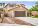 Charming two-story home with a paved driveway, a secure courtyard gate, and professional landscaping enhancing curb appeal at 7013 Bisoni St, Las Vegas, NV 89149