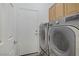 Functional laundry room featuring a modern washer and dryer set with built-in storage cabinets at 7013 Bisoni St, Las Vegas, NV 89149