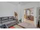 Spacious living room area with a gray sofa, vibrant rug, and an open doorway to adjacent spaces at 7013 Bisoni St, Las Vegas, NV 89149