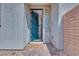 Inviting entryway showcasing a teal front door, brick accents and desert landscaping at 764 Aurora Vale Pl, Henderson, NV 89011