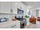 Well-equipped kitchen with stainless steel appliances, white cabinets, and an open layout to the living area at 764 Aurora Vale Pl, Henderson, NV 89011