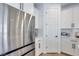 Clean kitchen with stainless steel refrigerator, white cabinets, and pantry access at 764 Aurora Vale Pl, Henderson, NV 89011