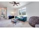 Bright living room with a comfortable sofa, ceiling fan, and carpet flooring at 764 Aurora Vale Pl, Henderson, NV 89011