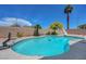 An inviting pool is enhanced by the lush landscaping and clear blue sky at 7726 Keating Cir, Las Vegas, NV 89147