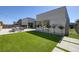 A modern home features a backyard with green grass, a patio, and flowering trees at 787 Willits St, Las Vegas, NV 89138