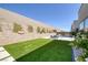 A modern backyard with green lawn and bright patio, set against a high privacy wall at 787 Willits St, Las Vegas, NV 89138