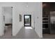 Bright, modern hallway with tile flooring, recessed lighting, and access to an office, kitchen, and outdoor patio at 787 Willits St, Las Vegas, NV 89138