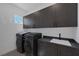 Laundry room with gray cabinets above appliances and counterspace with sink at 787 Willits St, Las Vegas, NV 89138