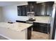 Modern kitchen featuring dark wood cabinetry, granite countertops, and stainless-steel appliances at 806 Star Estates Ave, North Las Vegas, NV 89086