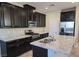 Modern kitchen featuring granite countertops and stainless-steel appliances and black cabinetry at 806 Star Estates Ave, North Las Vegas, NV 89086