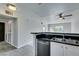 This is a kitchen with white cabinets, black countertops, and stainless steel appliances at 8070 W Russell Rd # 2121, Las Vegas, NV 89113
