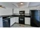 This is a kitchen with white cabinets, black countertops, and black appliances at 8070 W Russell Rd # 2121, Las Vegas, NV 89113