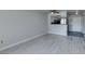 Neutral living room featuring wood-look flooring, adjacent to a kitchen and entry door at 8070 W Russell Rd # 2121, Las Vegas, NV 89113