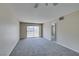 Open-concept living room with a ceiling fan and sliding doors to a balcony at 8070 W Russell Rd # 2121, Las Vegas, NV 89113