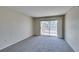 Spacious living room featuring neutral carpet, walls, and access to balcony with sliding glass doors at 8070 W Russell Rd # 2121, Las Vegas, NV 89113