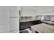 Contemporary kitchen with white and dark wood cabinetry, stainless steel backsplash, and granite countertops at 8134 Maddingley Ave, Las Vegas, NV 89117