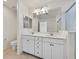 Bright bathroom featuring a dual sink vanity, large mirror, and a glass enclosed shower with marble-look surround at 8755 Spanish Ridge Ave, Las Vegas, NV 89148