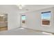 This bedroom features three windows that fill the space with natural light and neutral walls and carpet at 8755 Spanish Ridge Ave, Las Vegas, NV 89148