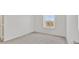 This bedroom features neutral colored walls and carpet, as well as a window with a view of the neighborhood at 8755 Spanish Ridge Ave, Las Vegas, NV 89148