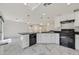 Modern kitchen featuring white cabinets, black appliances, and elegant marble floors at 8755 Spanish Ridge Ave, Las Vegas, NV 89148