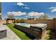 Backyard featuring a swim spa, artificial grass, and a covered seating area at 9638 Smiley Creek St, Las Vegas, NV 89178