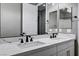Modern bathroom featuring a dual sink vanity with a marble countertop and dark fixtures at 9638 Smiley Creek St, Las Vegas, NV 89178